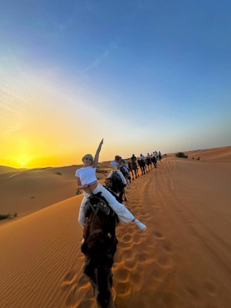 group of travelers riding camels at sunset on a 2 day desert tour from marrakech.