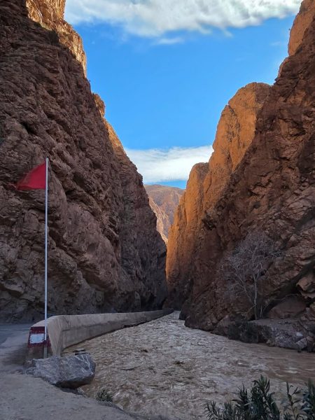 Walking through the towering rock canyon of Todra Gorges in Morocco.