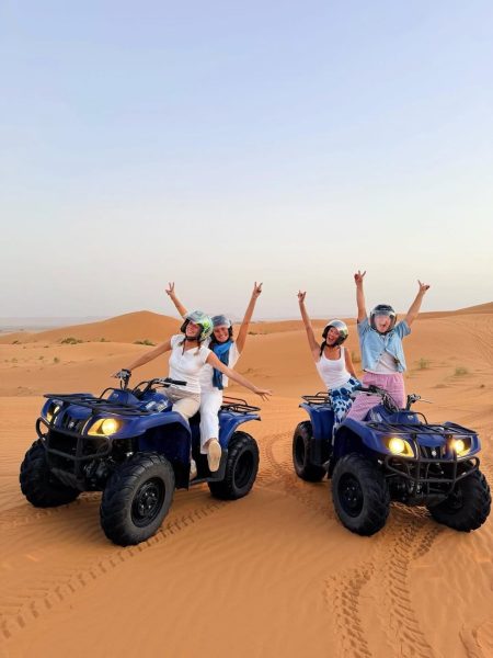 Traveler enjoying a quad biking adventure across the golden dunes of Merzouga Desert