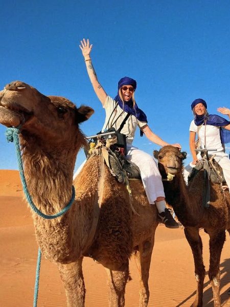 Travelers enjoying a camel trekking experience in the Sahara Desert during a 5-day tour from Casablanca
