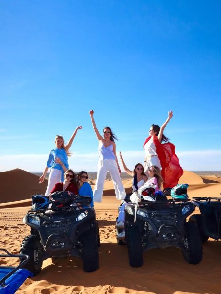 Travelers enjoying a quad biking adventure across the Sahara Desert dunes