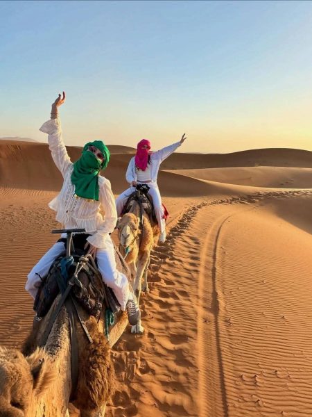 Traveler riding a camel through the golden Erg Chebbi dunes during a 7-day Morocco itinerary